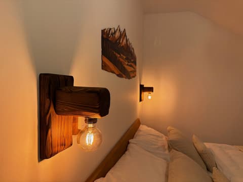 Wooden wall lamp with a filament bulb by the bed