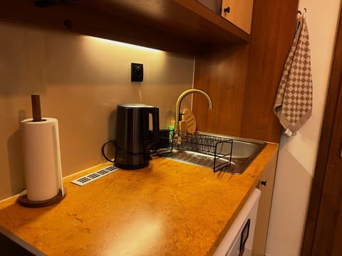 Worktop with kettle, sink and dish rack under the cabinet lighting